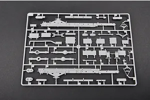 A grey plastic sprue containing various unpainted model kit parts for a 1/35 scale military vehicle, including chassis rails and suspension components.