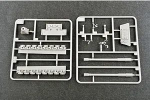 Two grey plastic model kit sprues containing tank parts including gun barrels, tracks, and hull components on a dark grey background.
