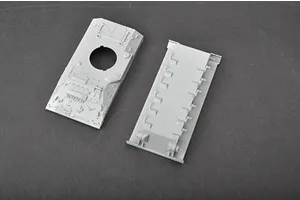 Two unpainted grey plastic model tank hull parts from a Trumpeter 1/72 scale British Warrior model kit, viewed from above on a dark surface.