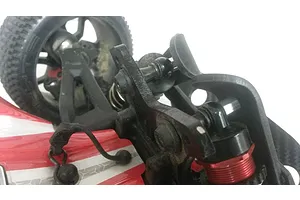 Close-up of a T-Bone Racing black skid plate installed on the front shock tower of an ARRMA Typhon RC buggy.