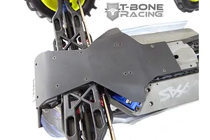 A T-Bone Racing black nylon skid plate installed on the front chassis of a Traxxas E-Maxx RC truck.