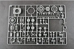 A grey plastic model kit sprue containing various helicopter parts, including engine components, wheels, and small mechanical details.