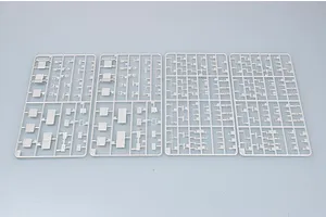 Four grey plastic model kit sprues containing various small aircraft parts for a 1/700 scale model ship.