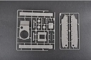 Two grey plastic model kit sprues containing tank parts, including hull sides and turret components, laid out on a dark grey background.