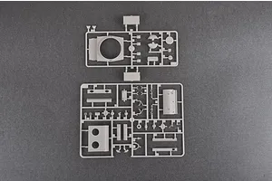 Two grey plastic model kit sprues containing various tank parts, laid out on a dark grey surface.