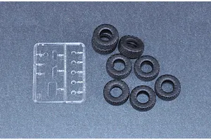 A set of seven black rubber tires and a small clear plastic sprue for a 1/35 scale model kit.