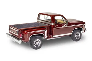 A completed 1/24 scale model of a 1976 Chevrolet Stepside pickup truck in deep metallic red with white side stripes.