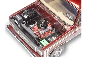 High-angle view of a 1/24 scale model 1976 Chevrolet pickup truck with the hood open, revealing a detailed engine bay.