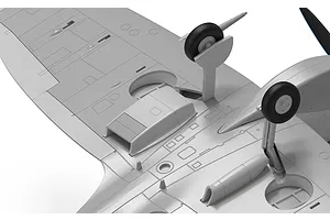 Close-up of the underside of an unpainted grey plastic model aircraft wing showing landing gear and panel details.