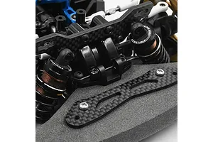 Close-up of a carbon fibre front shock tower installed on a Tamiya TT-02 RC car chassis with adjustable shocks.