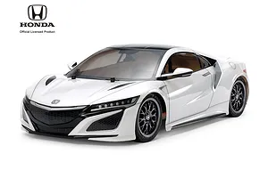 A studio shot of a white Tamiya Honda NSX RC car model on a white background, featuring black wheels and detailed bodywork.