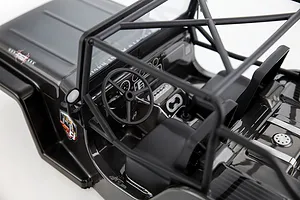 High-angle view of the interior of a grey RC crawler body shell featuring a roll cage, steering wheel, and dashboard details.