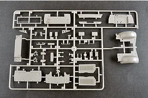 A grey plastic sprue containing various model kit parts for a military vehicle, viewed from above on a dark surface.