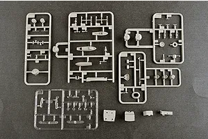 Several grey plastic model kit sprues and one clear plastic sprue containing various small ship parts on a dark grey background.