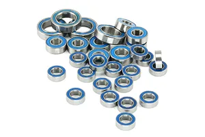 A collection of various sized metal ball bearings with blue Teflon seals scattered on a white background.