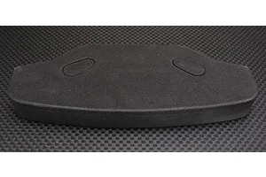 A black urethane foam bumper for an RC car, viewed from above against a carbon fiber pattern background.