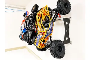 Two RC rock crawler vehicles mounted vertically on a wall using a T-Bone RC car wall rack system.