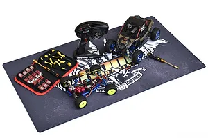 A large GPM Racing pit mat laid flat with an RC car, transmitter, and tool kit arranged on top.