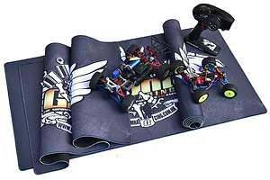 GPM Racing pit mat laid out with two RC cars and a remote control on top, featuring a dark grey design with white wing graphics and GPM branding.