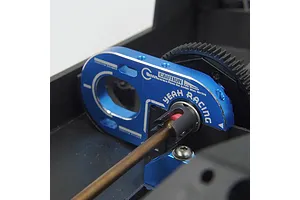 A blue anodized aluminium motor mount by Yeah Racing installed on a black RC chassis, showing the motor plate and drive shaft connection.