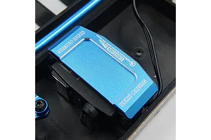 A blue anodized aluminium Yeah Racing servo mount installed on a black RC chassis, featuring engraved branding and caution text.