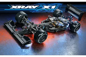 XRAY X1 1/10 scale electric formula RC car kit, showing the chassis, carbon fiber components, and black tires on a textured, reflective surface.