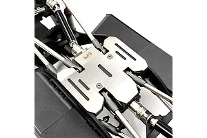 A stainless steel skid plate installed on the underside of an RC crawler chassis, featuring the Yeah Racing logo.