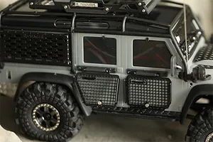 Close-up of a grey RC crawler vehicle featuring black metal window guards installed on the side doors.