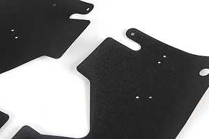 A close-up view of two black, textured RC dust guard panels with pre-drilled mounting holes against a white background.