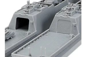 Close-up of two unpainted grey plastic model ship decks from the Tamiya 1/700 JMSDF FFM-1 Mogami kit, showing hangar doors and deck details.