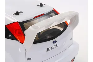 Close-up of the rear of a white Tamiya 2003 Ford Focus RS RC car body, showing the large rear spoiler, taillights, and body clips on a white background.