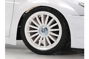 Close-up of a white Tamiya RC car wheel and tire on a white background.
