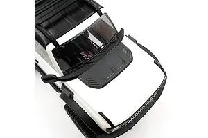 A close-up view of the hood of a white RC crawler vehicle featuring a black aftermarket engine hood intake accessory installed.