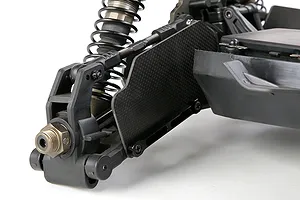 Close-up of a carbon fibre front suspension arm guard installed on an RC car, showing the weave pattern and mounting hardware.