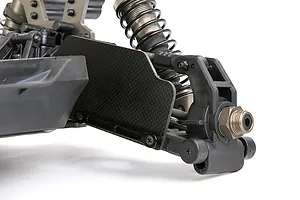 Close-up of a carbon fibre suspension arm guard installed on the front assembly of an RC vehicle against a white background.