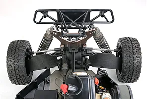 A close-up view of the rear suspension area of an RC buggy, featuring carbon fibre rear suspension arm guards installed on the lower control arms.