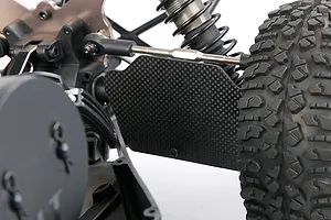 A close-up view of a carbon fibre rear suspension arm guard installed on an RC vehicle, showing the weave pattern and mounting position.