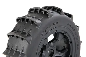 Close-up of a black Rovan 1/5 scale paddle tyre mounted on a black beadlock wheel, showing the tread pattern and sidewall markings.