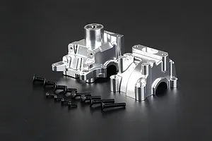 Rovan silver aluminium gearbox case set with included black mounting screws on a dark background.