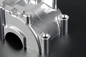 A close-up view of a silver Rovan aluminium gearbox case showing machined metal surfaces and mounting holes.