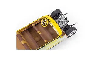 High-angle view of a partially assembled 1/25 scale Chevrolet Bel Air model car showing the yellow dashboard, brown bench seats, and chrome engine detail.