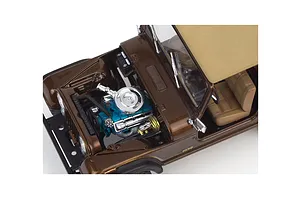 High-angle view of a brown 1/24 scale model Jeep CJ-7 with the hood open, revealing a detailed blue engine block and chrome air cleaner.