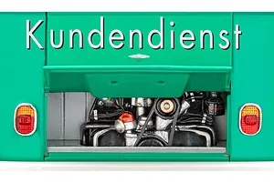 Close-up of the rear engine bay of a teal VW T1 model bus with the word Kundendienst printed above the open engine compartment.
