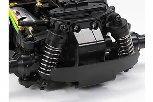 Close-up of the front suspension and bumper assembly of a Tamiya MB-01 RC car chassis.