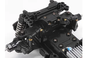 Close-up of the front suspension and chassis assembly of a Tamiya MB-01 RC car kit on a white background.
