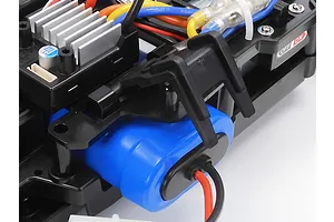 Close-up of the internal chassis components of a Tamiya MB-01 RC car, showing the battery, electronic speed controller, and wiring.
