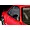 A close-up of a black racing-style door mirror mounted on the red body shell of a 1/10 scale RC car.