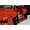 Close-up of a red RC car body installed with wide over fender flares and black wheels on a marble surface.
