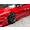Close-up of a red RC drift car body showing the front wheel, side skirts, and painted body details.