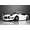 A front three-quarter view of a white Toyota 2000GT RC body shell with pop-up headlights open, parked on a reflective surface.